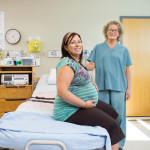 Happy Nurse And Pregnant Woman In Hospital Room